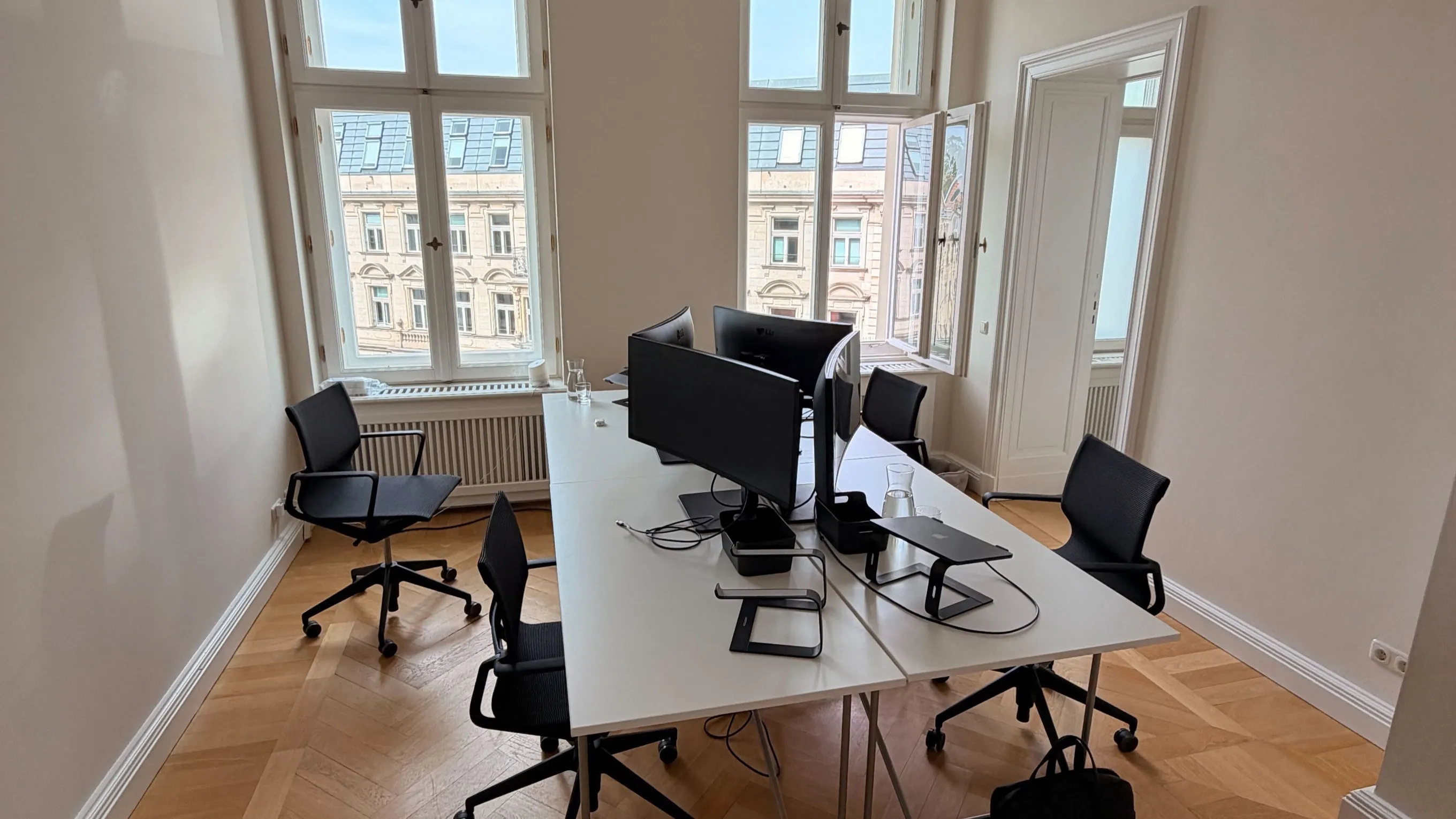 Das Büro von Sunpeak Capital in Berlin-Mitte, Schreibtische vor Altbaufenstern