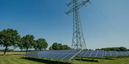 Freiflächen-Solaranlage unter einem Strommast mit Hochspannungsleitung