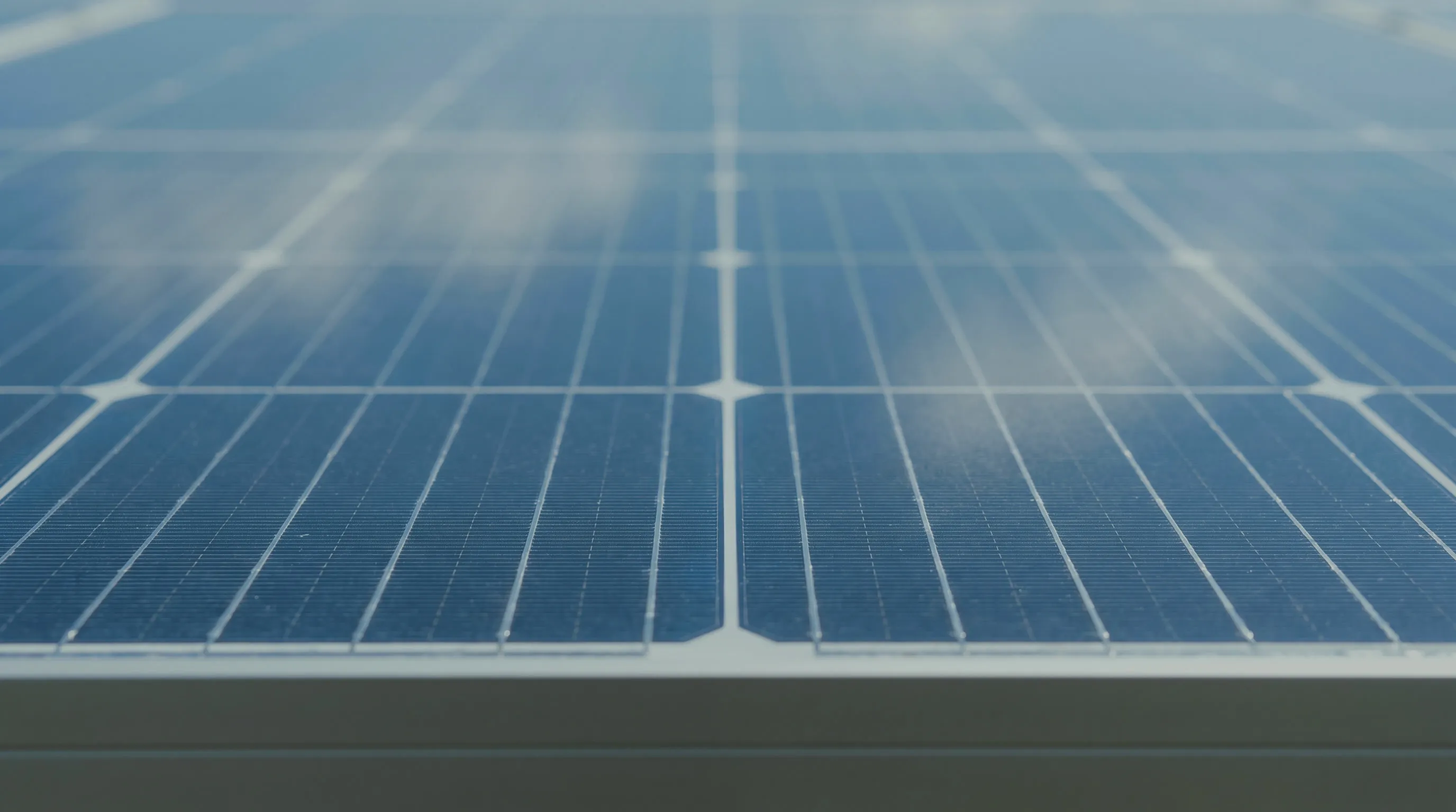 Nahaufnahme der Oberfläche eines Solarmoduls mit Zellstruktur und gespiegelten Wolken