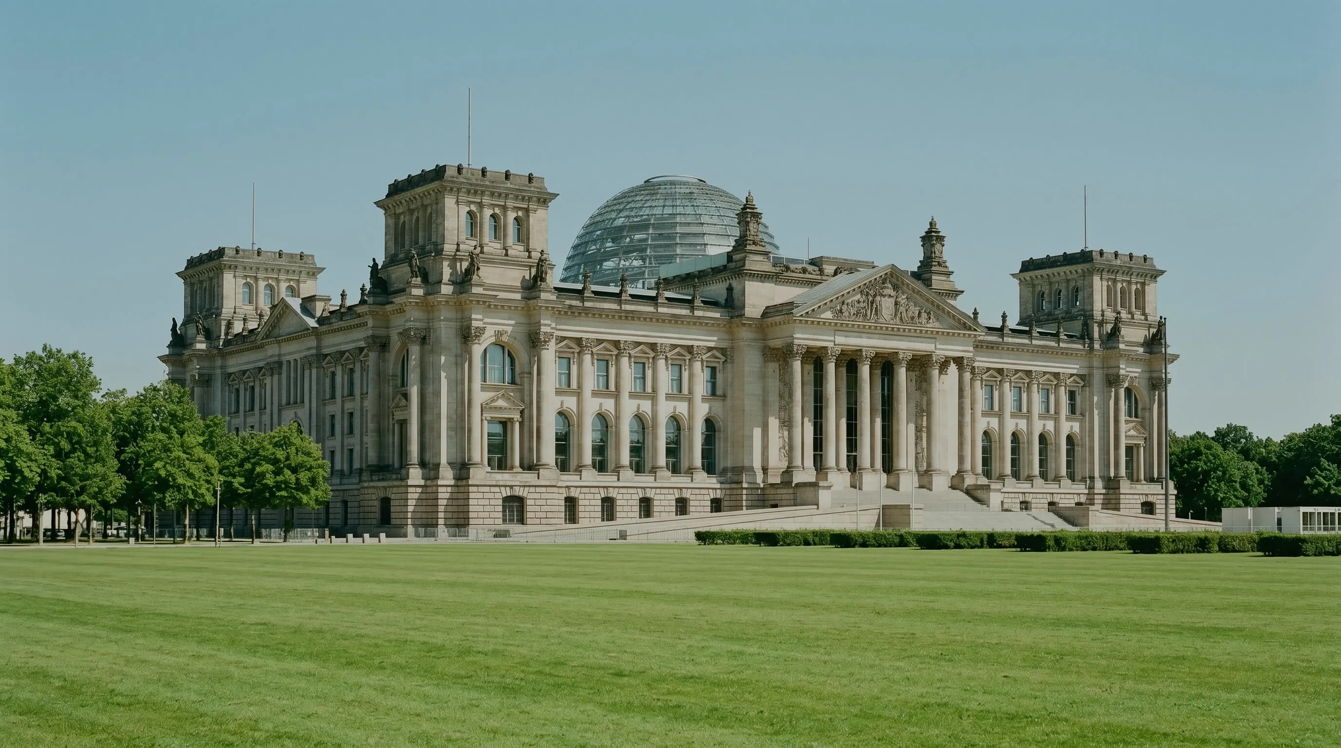 Regulatorische Risiken für Solar-Investoren: Reichstagsgebäude in Berlin mit Glaskuppel hinter einer weiten Rasenfläche